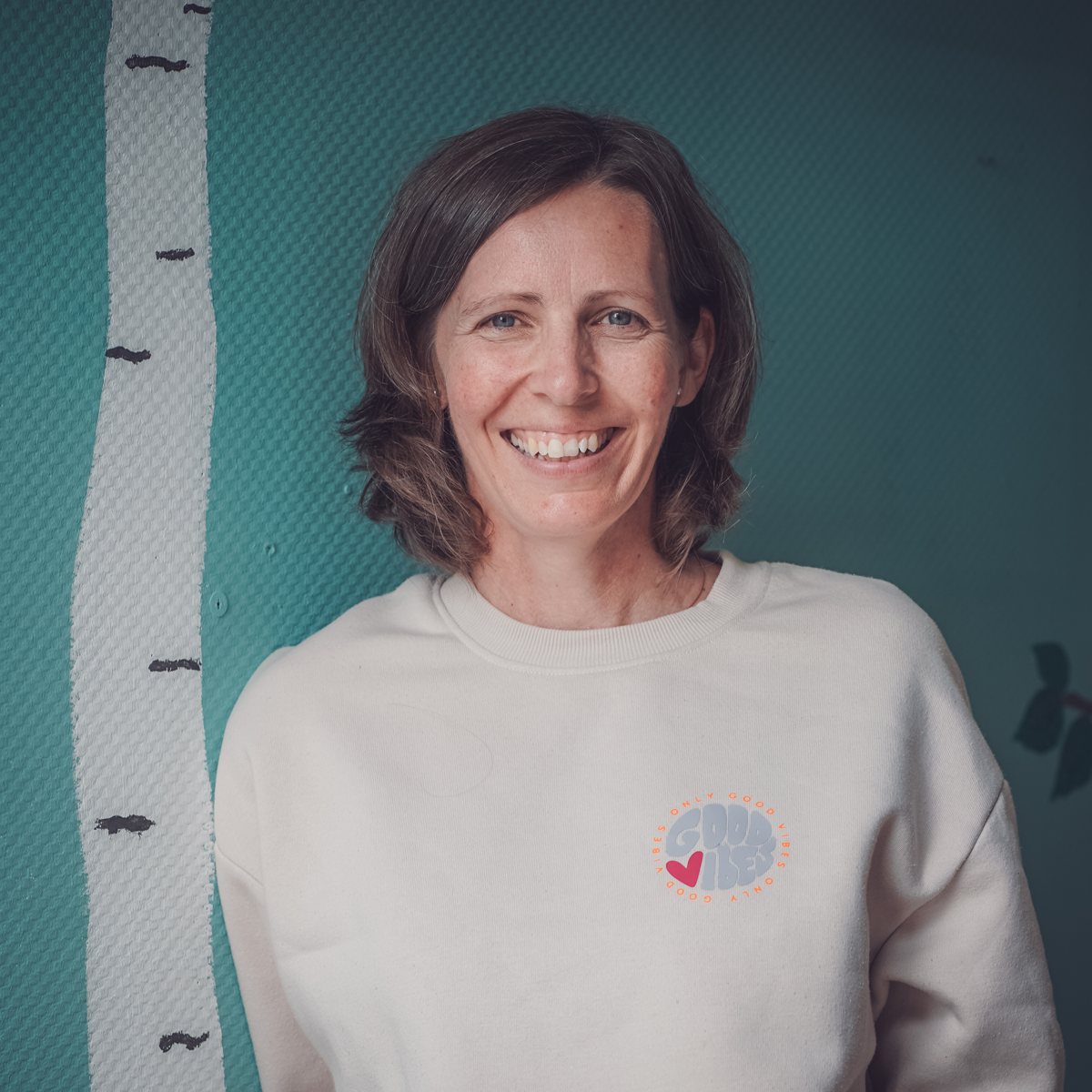 Simone Kluth lächelnd vor einer grünen Wand